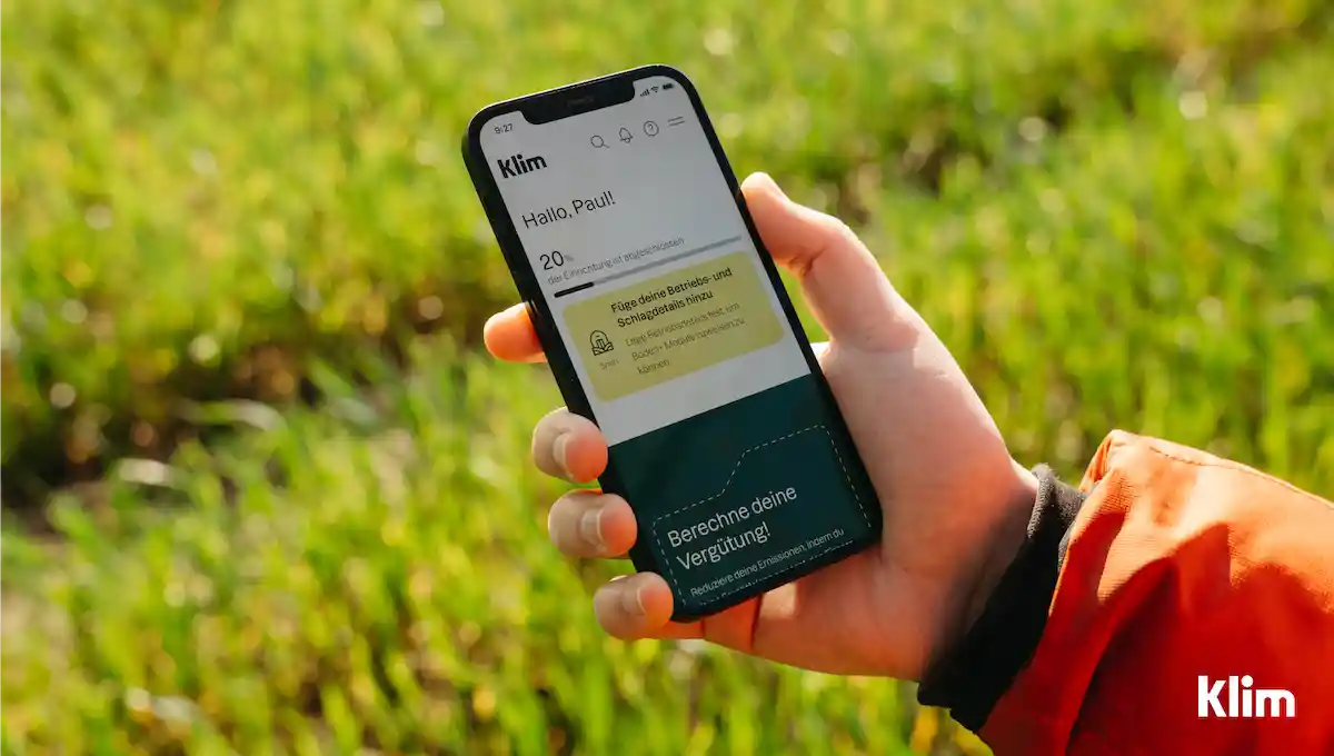 Klim app on mobile phone with field in the background
