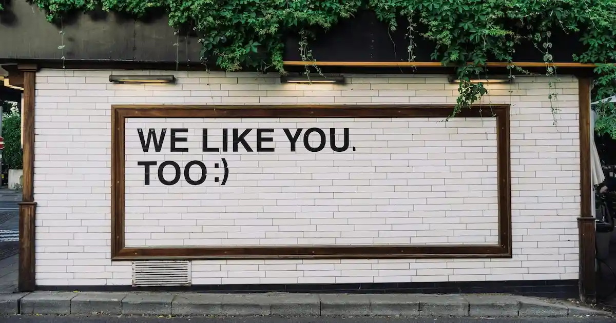 Framed sign on building that says 'We like you too'